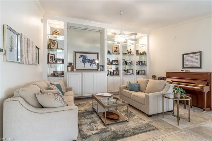 Living room with ceiling fan and ornamental molding