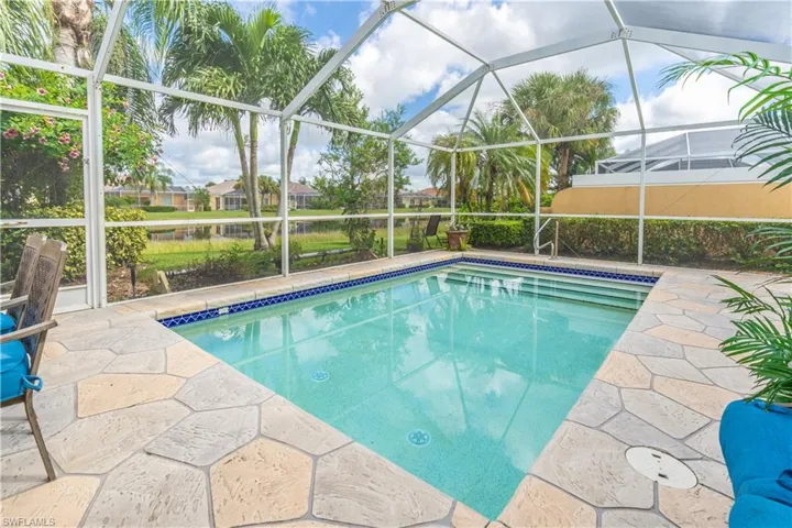 View of swimming pool with glass enclosure and a patio area