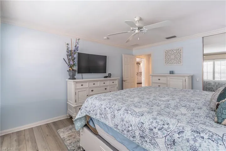 Bedroom featuring crown molding, light hardwood / wood-style flooring, and ceiling fan