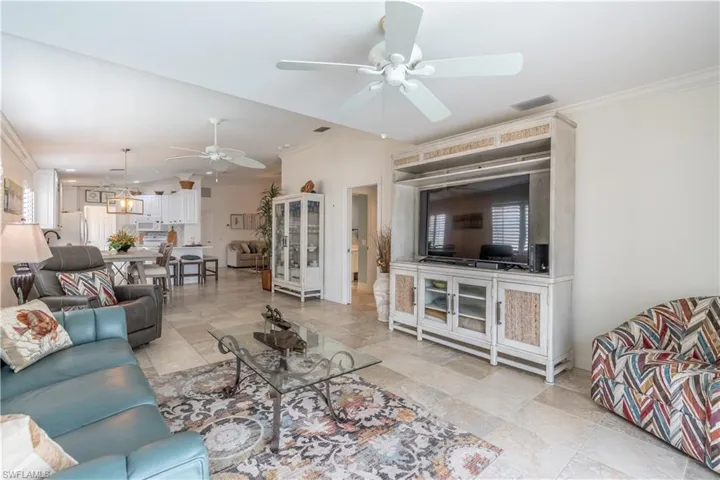 Living room featuring crown molding and ceiling fan
