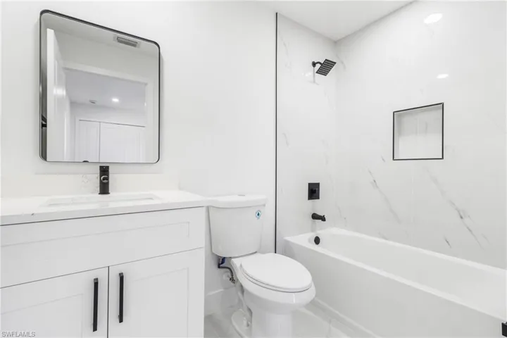 Bathroom with vanity, bathing tub / shower combination, and recessed lighting