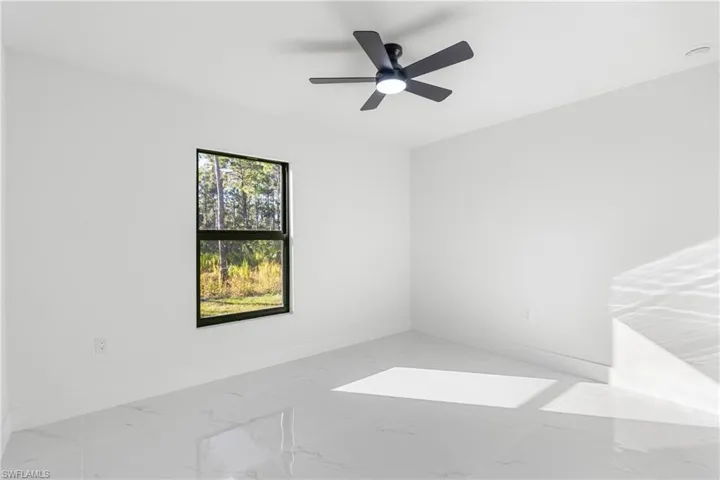 Unfurnished room featuring marble finish flooring and ceiling fan