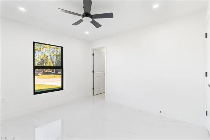 Empty room featuring light marble finish flooring, recessed lighting, and ceiling fan