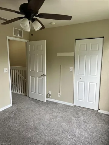Unfurnished bedroom with carpet flooring, a closet, and ceiling fan