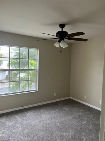 Unfurnished room featuring ceiling fan and carpet floors