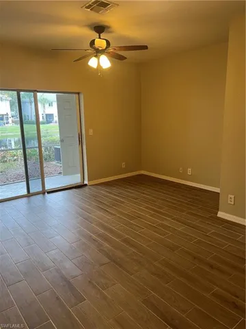 Unfurnished room featuring ceiling fan and dark hardwood / wood-style flooring