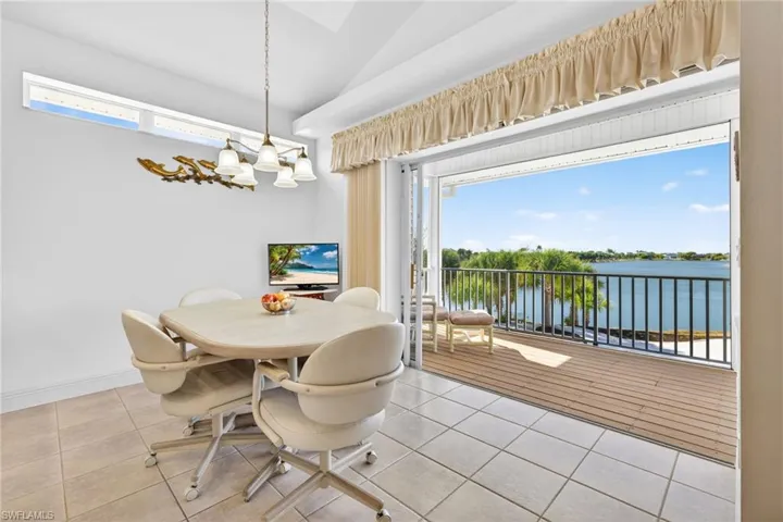 Dining space featuring lofted ceiling, light tile patterned floors, and a chandelier