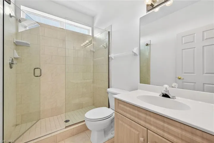 Full bath featuring vanity, a stall shower, and tile patterned flooring