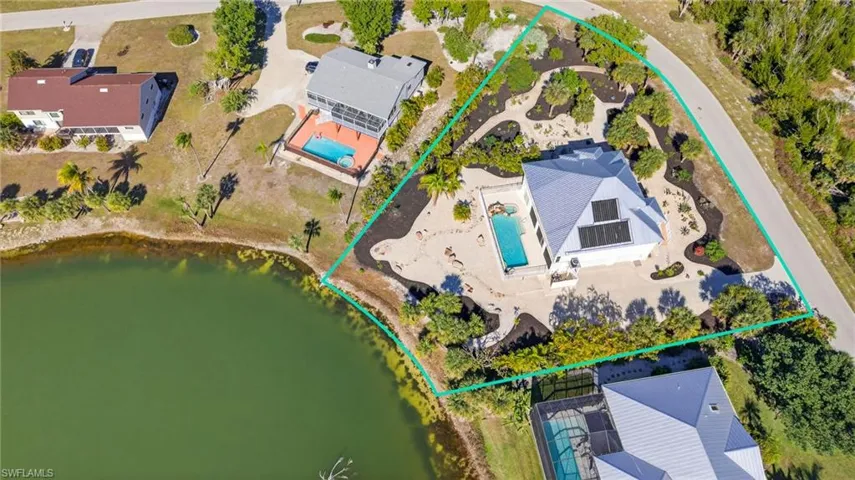 Aerial view of property and surrounding area featuring a large body of water and property boundaries highlighted