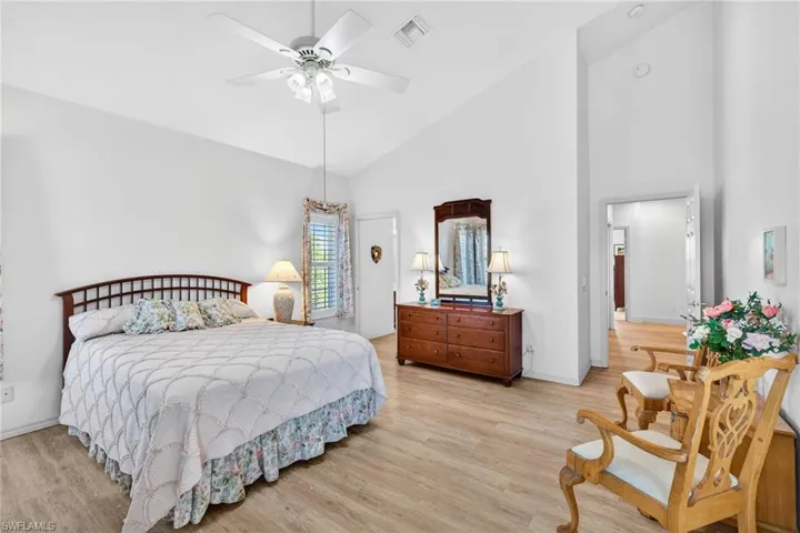 Bedroom with high vaulted ceiling, light wood finished floors, and ceiling fan