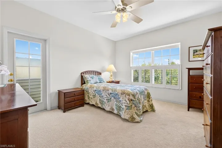 Bedroom with light carpet, ceiling fan, and access to exterior