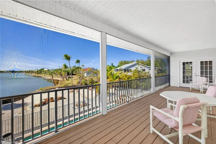 Deck featuring a water view, french doors, and a sunroom