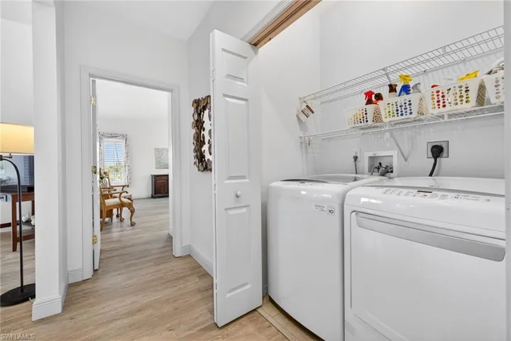 Laundry area with light wood finished floors and independent washer and dryer