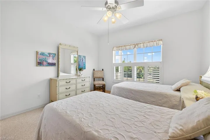 Bedroom with light colored carpet and ceiling fan