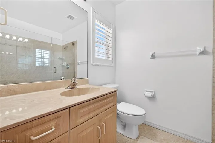 Bathroom with vanity, a shower stall, and light tile patterned floors