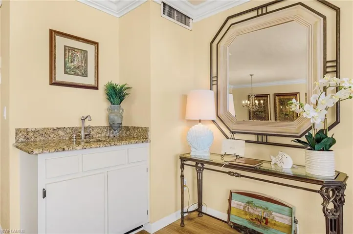 Details with crown molding, hardwood / wood-style flooring, sink, and an inviting chandelier