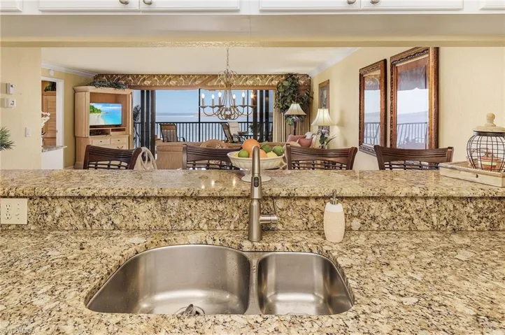 Kitchen featuring sink, crown molding, decorative light fixtures, and plenty of natural light