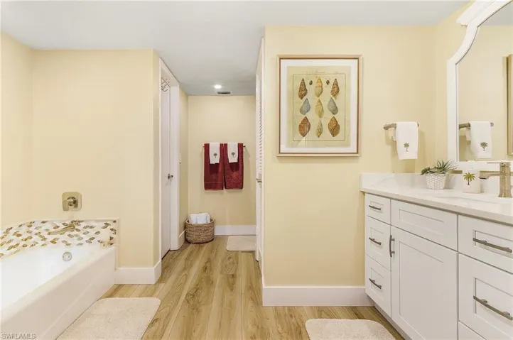 Bathroom with vanity, wood-type flooring, and a tub