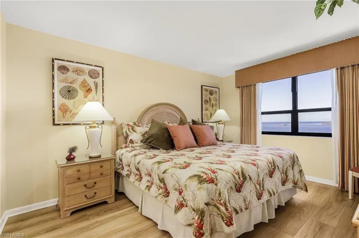 Bedroom with a water view and light hardwood / wood-style floors