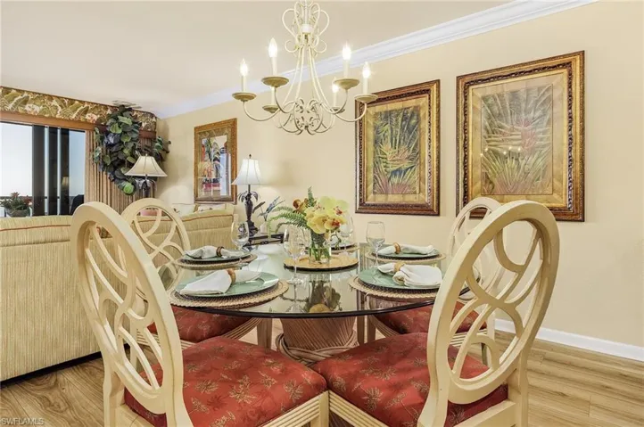 Dining room featuring crown molding, hardwood / wood-style flooring, and a chandelier