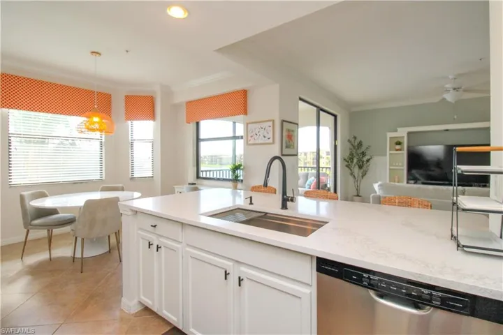 Kitchen with white cabinets, ceiling fan, sink, dishwasher, and hanging light fixtures