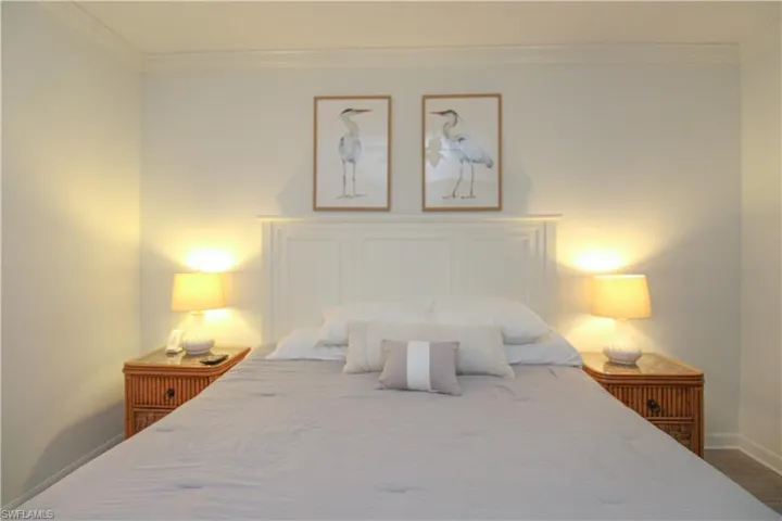 Bedroom with hardwood / wood-style floors and ornamental molding