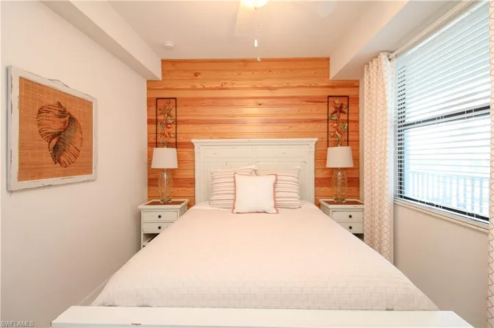 Bedroom with ceiling fan and wooden walls