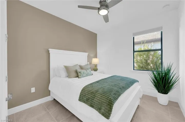 Bedroom with ceiling fan and light tile patterned floors