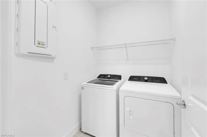 Washroom featuring washing machine and dryer and electric panel