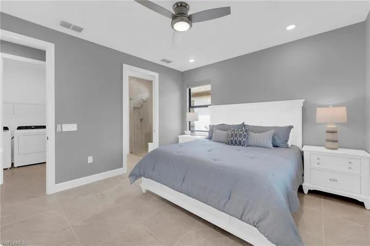 Bedroom with recessed lighting, a ceiling fan, connected bathroom, washing machine and dryer, and light tile patterned flooring