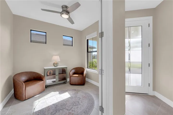 Living area featuring light tile patterned flooring and a ceiling fan