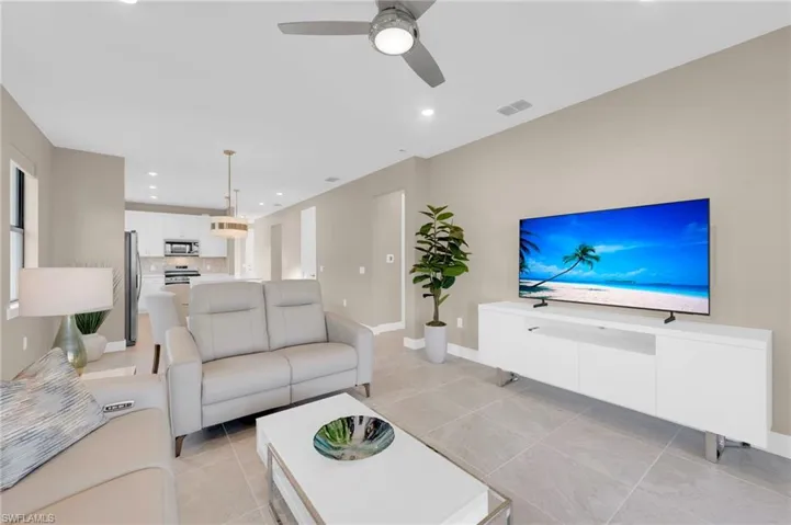 Living area featuring recessed lighting, a ceiling fan, and light tile patterned floors