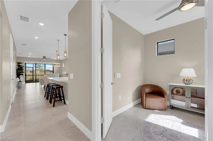 Hall with light tile patterned floors and recessed lighting