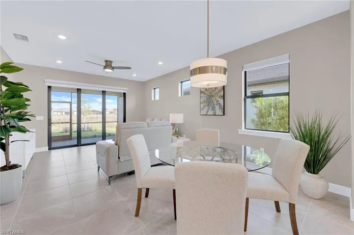 Dining room featuring healthy amount of natural light, ceiling fan, recessed lighting, and light tile patterned floors