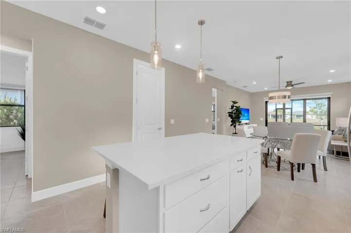 Kitchen featuring white cabinetry, decorative light fixtures, recessed lighting, a center island, and open floor plan