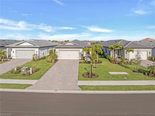 Single story home featuring a front lawn, decorative driveway, an attached garage, and a residential view