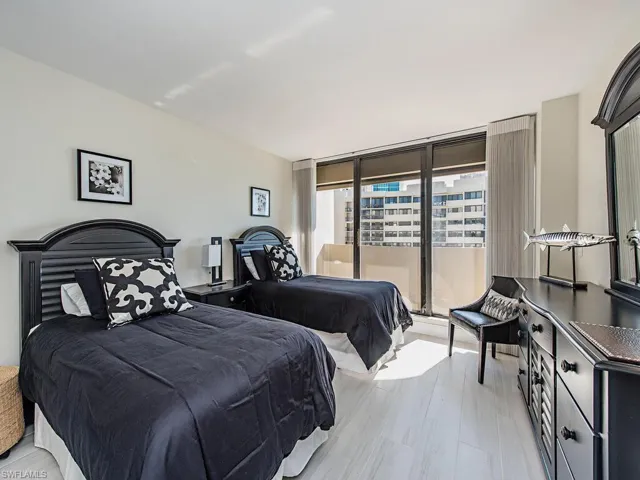 Bedroom with access to exterior, light wood-type flooring, and floor to ceiling windows