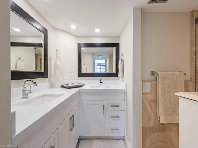Full bathroom with double vanity and recessed lighting