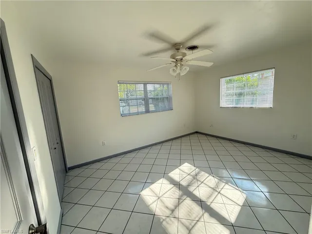 Unfurnished bedroom with a closet, a ceiling fan, and light tile patterned floors