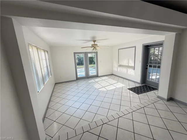 Unfurnished room with ceiling fan and light tile patterned floors