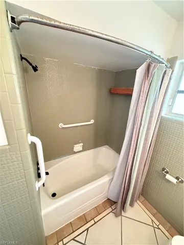 Bathroom featuring light tile patterned flooring and shower / bath combo