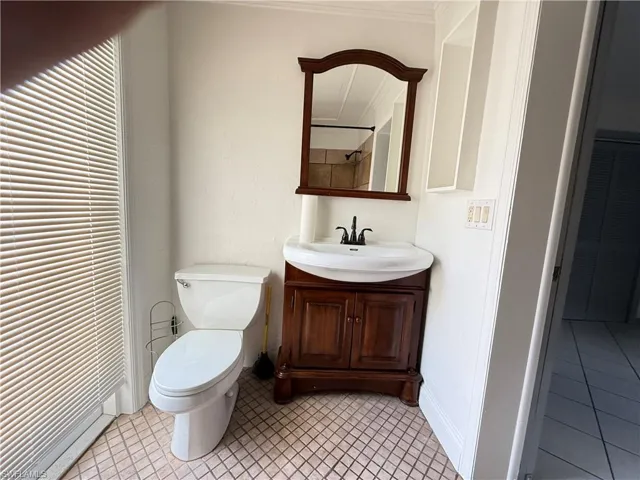 Bathroom with vanity, light tile patterned floors, and a closet