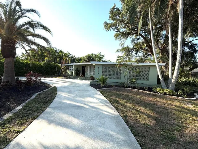 Ranch-style house with driveway and a front yard