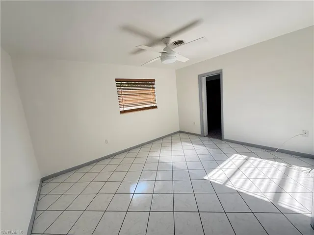 Empty room featuring a ceiling fan and light tile patterned floors