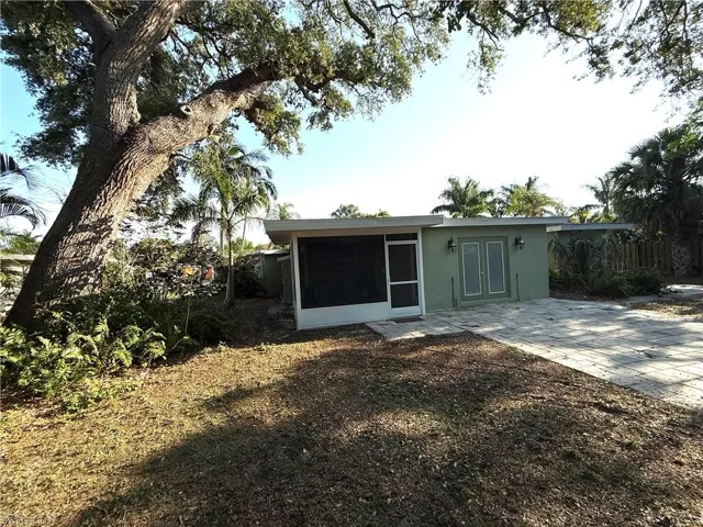 View of front of home with stucco siding, a patio area, french doors, and a sunroom