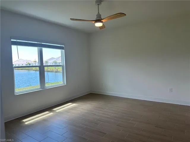 Primary Bedroom with Tile Flooring and Ceiling Fan and a Water View