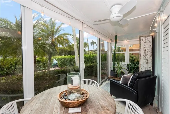 Sunroom with tile patterned floors, roll-down shades and alfresco dining