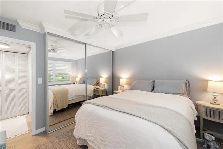 Bedroom featuring crown molding, wood finished floors, a closet, and ceiling fan