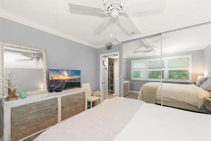 Bedroom with ornamental molding and ceiling fan