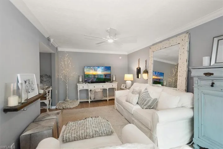 Living room featuring ornamental molding, wood finished floors, and ceiling fan